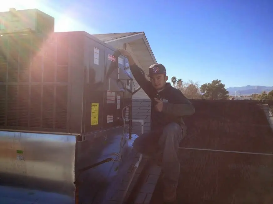 HVAC technician performing AC Tune-Up on a rooftop unit in Sarasota Springs